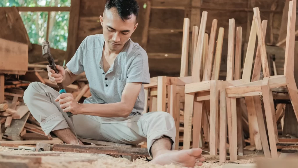 A skilled craftsman shaping furniture using the Best Wood for Carving, ensuring durability and intricate details