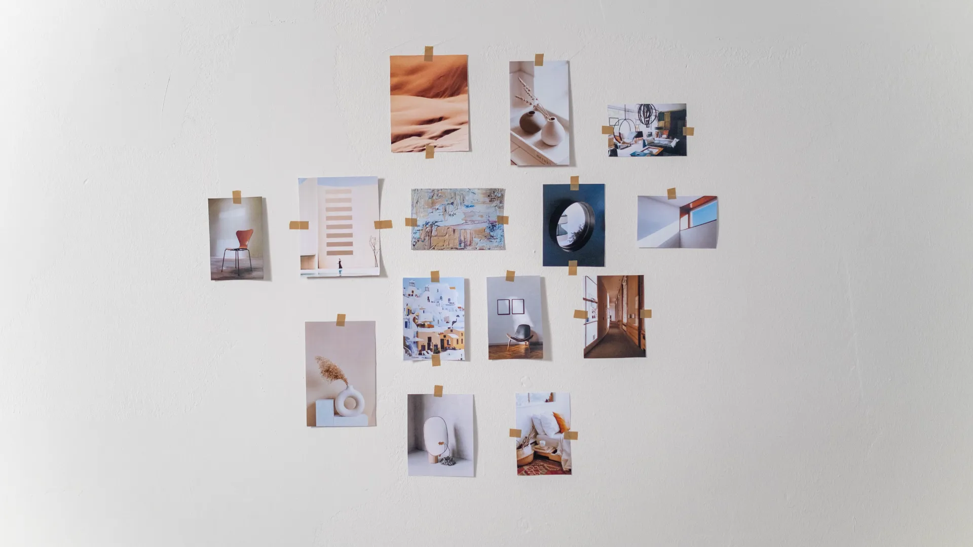 A collage of Minimalist Aesthetic Wall Art pieces taped to a white wall, featuring neutral tones and modern design.