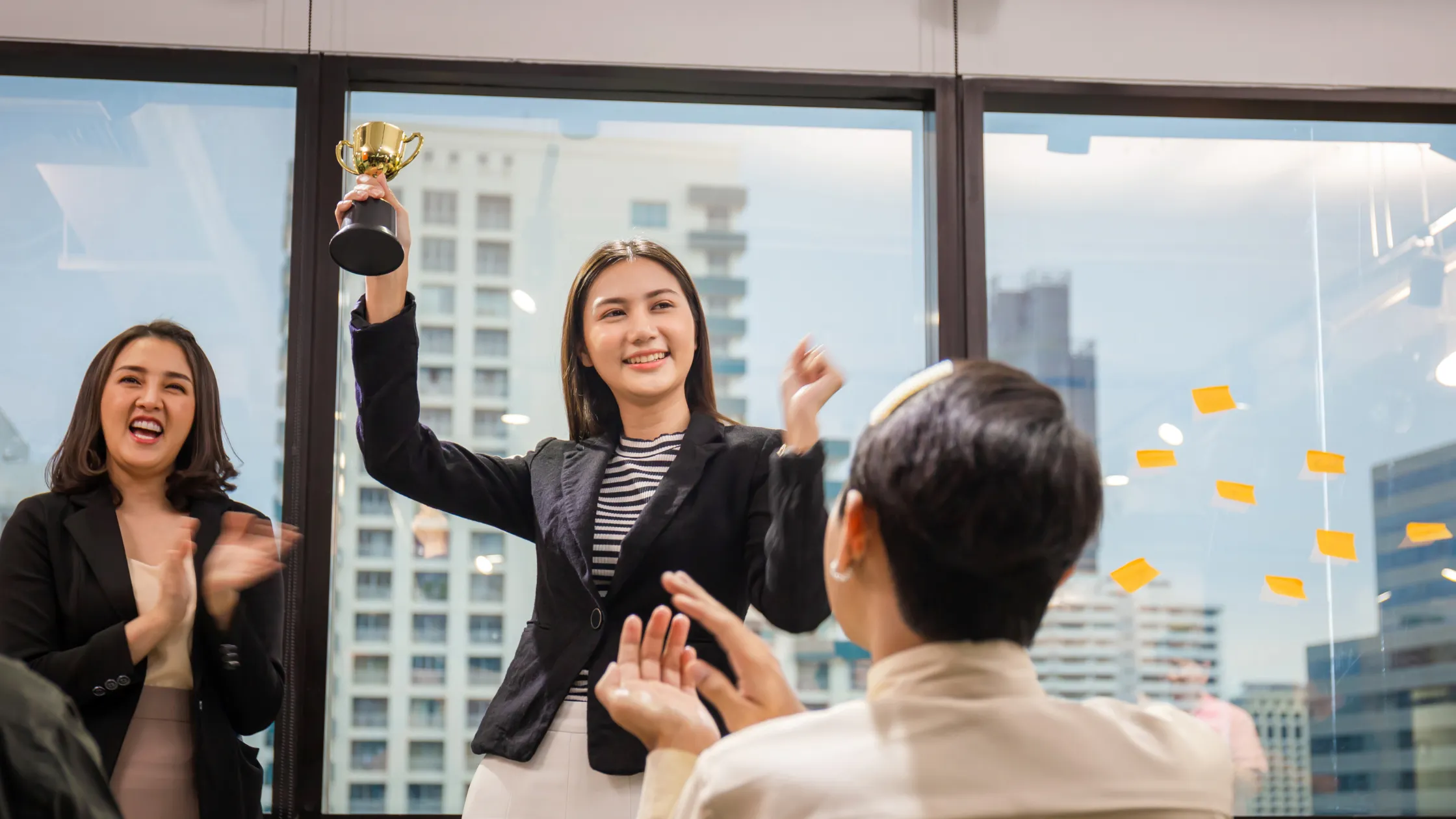 Winner holding a trophy at the Miramar Business Awards ceremony, surrounded by applauding colleagues.