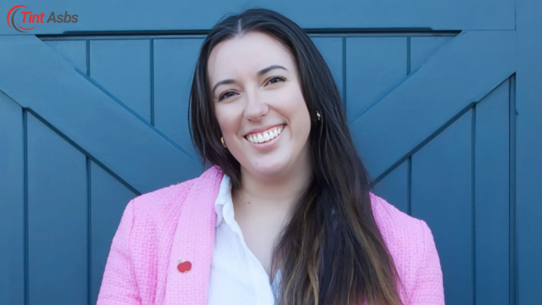 Natalie Zimmerman smiling in a pink cardigan with a blue background, supporting the Natalie Zimmerman Board of Education.