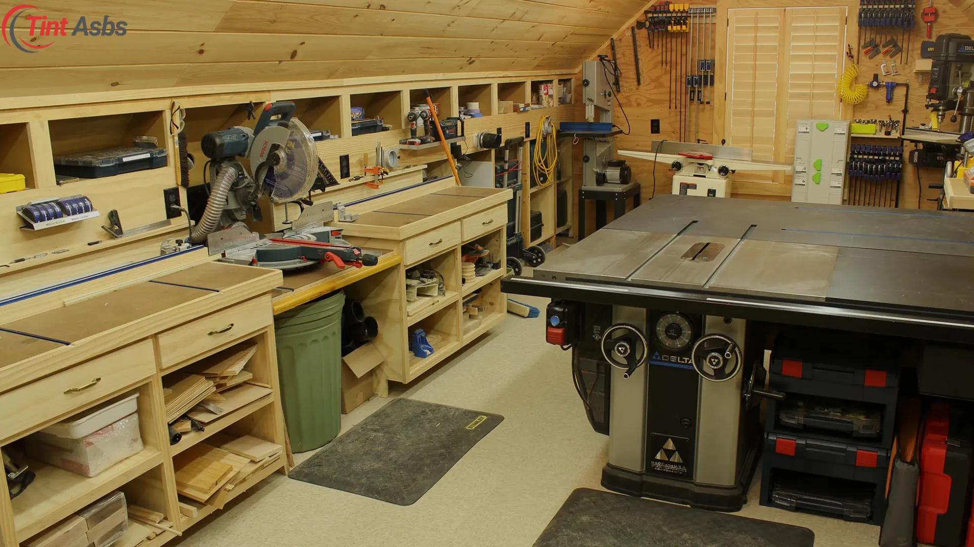 Wood shop layout setup with well-organized tools, miter saw, and spacious workbenches.